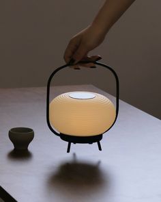 a person holding a light on top of a table