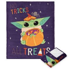 a purple towel with an image of a baby yoda holding a pumpkin and the words no tricks all treats on it