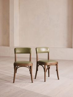 two chairs sitting side by side in an empty room