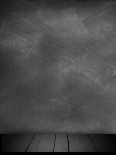 a black and white photo of an empty room with wood flooring in front of a chalkboard wall