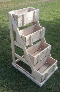 three wooden crates are stacked on top of each other in the grass, one is empty