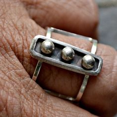 Sterling Silver and fine silver combine in a stylishly modern ring that was handmade in my studio.  I call it "Captivity".  The ring forms a cage around your finger and the 3 fine silver spheres are captive in the center portion of the ring.  It is a unique and captive-ating design.The ring is a US size 6.  The open band is just under 1/2 inch wide and the top of the ring is 2cm long or about 3/4 inch and it is 1/4 inch wide or about 6mm.  The back has a satin finish and is stamped 'sterling'. Hand Forged Sterling Silver Modernist Rings, Modernist Hand Forged Sterling Silver Rings, Modern Sterling Silver Hand Forged Stackable Rings, Modern Hand-forged Sterling Silver Stackable Rings, Hand Forged Modern Sterling Silver Ring, Modern Hand Forged Sterling Silver Ring, Modernist Sterling Silver Rings For Everyday, Modernist Sterling Silver Everyday Rings, Modern Hand Forged Silver Stackable Rings