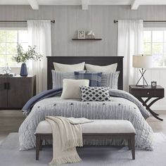 a bed with blue and white pillows in a bedroom