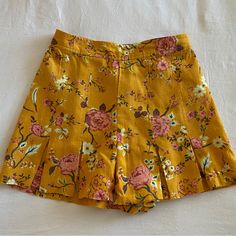 Mustard Yellow Floral Skirt With Front Pleats. 55% Linen And 45% Rayon Never Worn - No Tags Summer Skirted Bottoms With Built-in Shorts, Fitted Skirted Summer Bottoms, Pleated Mini Shorts For Day Out, Mini Length Pleated Shorts For Day Out, Pleated Skirt For Summer Day Out, Summer Floral Print Skirted Bottoms, Spring Bottoms With Built-in Shorts And Mini Length, Skirted Cotton Shorts For Summer, Cotton Skirted Shorts For Summer