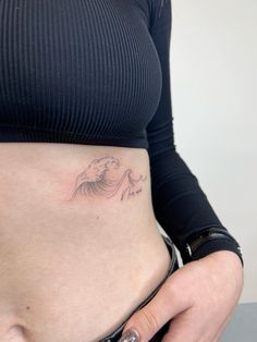 a woman's stomach with a tattoo on it