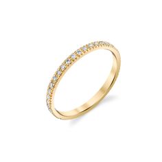 a yellow gold wedding band with small diamonds on the side, set against a white background