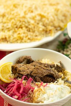 two bowls filled with food on top of a red and white table cloth next to rice