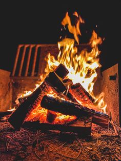 a pile of logs sitting in front of a fire