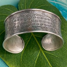 An exquisite work of art this Silver Cuff Bracelet was handmade by the Karen Hill Tribe in Northern Thailand.  The Karen people have spent centuries living and working close to nature and you can see their appreciation here in their hand-hammered work and details.   This bracelet is 98.5% Silver.  The high silver content produces a softer workable metal and will be able to mold to your wrist for the perfect fit.   * Fast U.S Based Shipping * Measures 5.5 " L x 2.5 " W  * 29 Gram Silver  * Ships Handmade Adjustable Nature-inspired Cuff Bracelet, Bohemian Adjustable Engraved Bangle, Traditional Wide Band Engraved Jewelry, Traditional Engraved Wide Band Jewelry, Elegant Engraved Bangle For Festival, Adjustable Intricate Cuff Bracelet For Ceremonial Use, Ceremonial Adjustable Cuff Bracelet With Intricate Design, Adjustable Intricate Design Cuff Bracelet For Ceremonial Occasions, Adjustable Sterling Silver Bracelet With Intricate Design