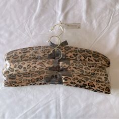 an animal print purse with metal handles on a white sheeted bedding material covered in clear cellophane