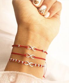 a woman's hand with three bracelets on it