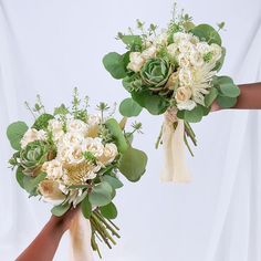 two brides hands holding bouquets of flowers and greenery