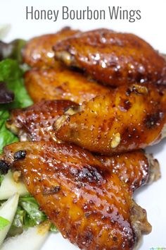 grilled chicken wings with lettuce and carrots on a white plate text reads honey bourbon wings