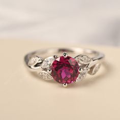 All HANDMADE ITEMS SHIP IN APPROX 8 DAYS Main Stone: Lab created ruby Main Stone Size: Round cut 7 mm x 7 mm Main Stone Weight: 1.61 carat Side Stone: Round shaped CZ,Marquise cut CZ Height From The Ring Setting Bottom(to gemstone top): about 6.07 mm Width of Ring band Measure: gradually varied,about 1.81-2.19 mm Material: 925 Sterling Silver/14K White Gold/14K Yellow Gold/14k Rose Gold Engraved: Available For FreeNo more than 13 letters) Customized:Of course! Tell me what you want Includes With Lab-created Ruby Birthstone Ring With Gemstone, Silver Birthstone Ring With Ruby, Silver Birthstone Ring With Round-cut Lab-created Ruby, Silver Birthstone Ring With Lab-created Ruby In Round Cut, Silver Jewelry With Round Lab-created Ruby, Silver Birthstone Ring With Lab-created Ruby, Round Ruby Flower Promise Ring, Lab-created Ruby Birthstone Jewelry For Promise Ring, Silver Solitaire Jewelry With Lab-created Ruby