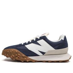 The New Balance XC72 'Navy Gum' is a modern take on a classic design. Inspired by 1970s concept cars, the sneaker features a unique three-traction outsole that gives it a bold, experimental edge. The dark blue, white, and brown colorway is perfect for any activity, from running to walking. The rubber sole provides superior cushioning and stability, making it the perfect choice for any adult. The XC72 is a stylish and innovative sneaker that will take you to the unknown. (SNKR/Retro/Light/Unisex/Low Top) Navy Outdoor Sneakers With Vibram Sole, Navy Low-top Sneakers For Outdoor, Navy Low-top Outdoor Sneakers, Functional Navy Sneakers With Rubber Sole, Navy Sneakers With Vibram Sole For Streetwear, Navy Functional Sneakers With Rubber Sole, Casual Navy New Balance Running Shoes, Navy Sports Sneakers With Vibram Sole, Navy Sports Sneakers With Gum Sole