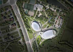 an aerial view of a large building surrounded by green grass and lots of trees in the background