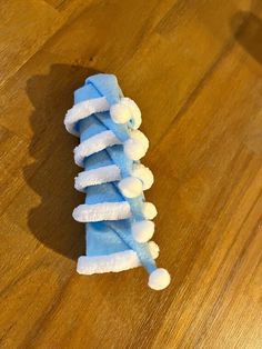 a pile of blue and white toothbrushes sitting on top of a wooden floor