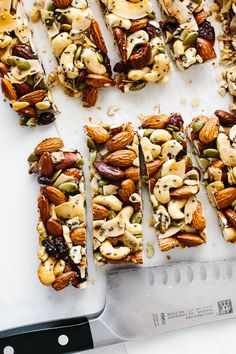 nuts and seeds are cut into squares on a cutting board