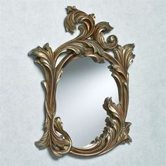 an ornate gold framed mirror on a wall