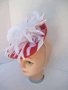 "* Red and White always looks so fresh and clean and this one is designed with lots of white spiky feathers that catch the breeze giving a feminine flair to the fascinator. * The hat form is about 12\" folded in back and tilted in a sophisticated design. * It is light weight, balanced and comfortable to wear year round. * Designed on a metal headband, it fits just about any head size and when viewed from any direction it looks complete, striking and eye catching. * Wear it throughout the year fo Summer Ostrich Feather Mini Hats For Races, Summer Mini Hats With Ostrich Feathers For Races, Summer Races Mini Hat With Ostrich Feathers, Summer Race Day Mini Hats With Ostrich Feathers, Red Feathered Fascinator For Kentucky Derby, Red Feathered Fascinator Hat, Red Feathered Hat Fascinator, Summer Feather Headpiece With Curved Brim, Red Feathered Costume Hat