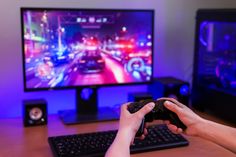 a person holding a game controller in front of a tv