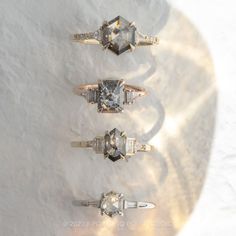 three different types of rings sitting on top of a white surface with light shining through them