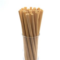 a glass filled with brown paper straws on top of a table