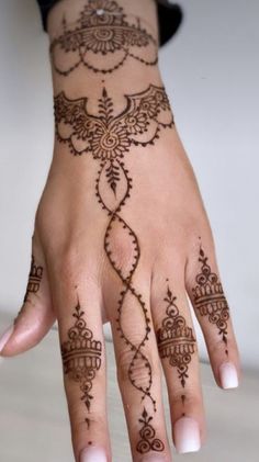 a woman's hand with hennap on it and an intricate design in the middle