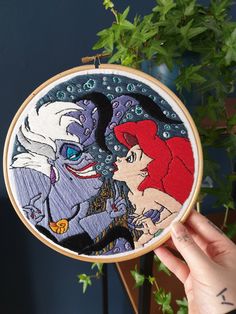 the little mermaid and prince ariel from disney's sleeping beauty are featured in this hand embroidered hoop art