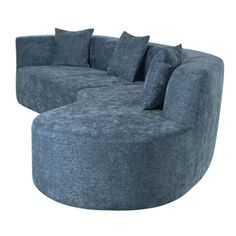 a large blue couch sitting on top of a white floor next to a round ottoman