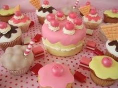 there are many cupcakes on the table with pink frosting and icing