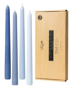 three blue candles sitting next to each other in front of a cardboard box on a white background