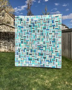 a blue and white quilt sitting in the grass