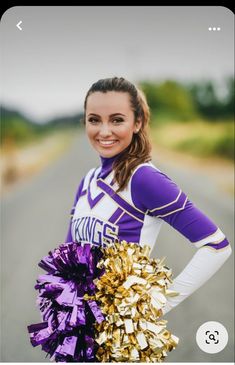 a cheerleader is posing on the road with her pom - poms in hand