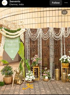 an outdoor wedding setup with flowers and garlands on the wall, in front of a building