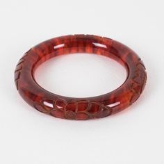 This is part of Chairish’s Costume Jewelry assortment.  Stunning red tea amber marble Bakelite bracelet bangle. Chunky rounded domed shape with a deep floral carving all around. Intense orange-red color with lots of cloudy swirling and translucency. Measurements: Inside across is 2.50 in diameter (6.4 cm) - outside across is 3.63 in diameter (9.2 cm) - width is 0.57 in wide (1.4 cm) - the wall is 0.57 in thick (1.4 cm).  Please see the measurements noted above in the description for the best app Elegant Tortoiseshell Bangle Jewelry, Handmade Bakelite Bangle Bracelet, Vintage Red Round Bangle, Handmade Round Bakelite Jewelry, Elegant Bakelite Bracelet Jewelry, Elegant Bakelite Bangle As Gift, Elegant Bakelite Bracelet, Elegant Bakelite Bangle As A Gift, Elegant Bakelite Bracelets As A Gift