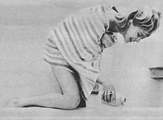 a woman is sitting on the floor in front of a sink