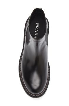 Prada's iconic stamped logo adds a heritage signature to a sleek leather Chelsea boot boldly updated with a tiered platform sole ridged to look like a chocolate bar. Pull-on style with elastic gore insets Leather upper and lining/synthetic sole Made in Italy Designer Shoes Luxury Chelsea Boots With Rubber Sole, Classic Calf Leather Platform Boots With Leather Lining, Classic Leather Platform Boots With Leather Sole, Luxury Round Toe Platform Boots For Work, Luxury Platform Boots With Lug Sole, Classic Calf Leather Platform Boots With Round Toe, Luxury Calf Leather Platform Boots With Leather Sole, Luxury Leather Boots With Lug Sole, Classic Leather Platform Boots