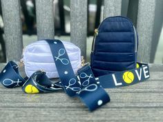 a blue purse sitting on top of a wooden bench next to a wrist bag and lanyard