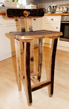 a wooden stool sitting on top of a hard wood floor next to a kitchen counter