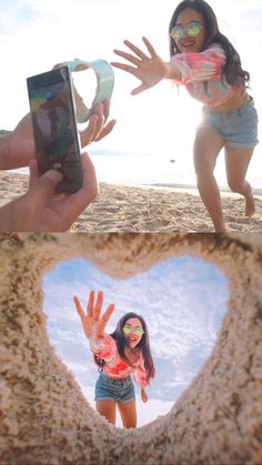 two girls are playing in the sand with their cell phones and one girl is making a heart shape