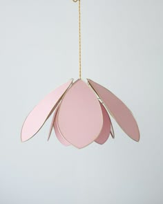 a pink flower hanging from a gold chain