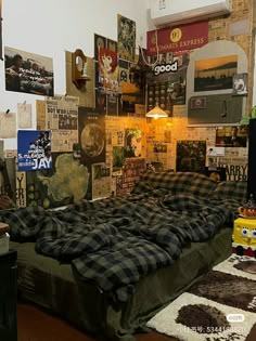 a bed with plaid sheets and pillows in a room full of posters on the wall