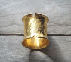 This is a handmade ring made from a bronze sheet then soldered and hammered and finally gold plated 24ct MATERIALS: gold plated bronze DIMENSION:2 cm height(0,8 inch approximately) I can make this ring to your size.You can find your size by looking here:http://www.bluenile.com/pdf/bluenile_ringsizer_copyright2008.pdf Every ring is handmade and unique. You will receive a very similar to the photo but not identical. I will pack your ring in a gift box as in my last photo.See my shop policies here: Artisan Gold Ring With Hammered Detail, Artisan Gold Hammered Rings, Artisan Hammered Gold Rings, Unique Gold Hammered Wide Band Ring, Hand Forged Gold Wide Band Ring, Unique Hammered Gold Wide Band Ring, Hand Forged Gold Wide Band Ring Gift, Hammered Brass Wide Band Jewelry, Architectural Rings