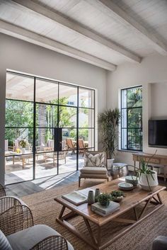 a living room filled with furniture and a flat screen tv on top of a wooden table