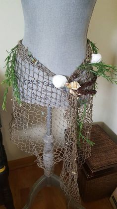 a mannequin is covered with netting and flowers