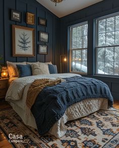 a bedroom with blue walls and wood flooring has a large bed in the corner