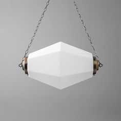 a white light fixture hanging from a chain