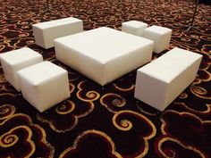 a group of white cubes sitting on top of a carpeted floor next to each other