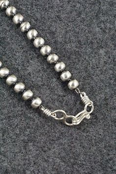 This sterling silver Navajo pearl necklace was made by Navajo silversmith Dorinda Mariano.Necklace: 20"Bead size: 3/16" x 3/16" (5mm x 5mm)Free shipping on all orders! We ship with USPS and always include tracking. All orders ship within a day of payment.Returns are accepted up to 30 days after you receive your order. Just send us a message. Our shop offers cash back or store credit. The item must be returned in new condition. Native American Jewelry, Pearl Necklace, Sterling Silver, Beads, Free Shipping, Silver, Native American Jewellery